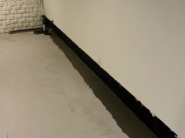 Completed interior basement waterproofing with perimeter drainage channel and sump pump