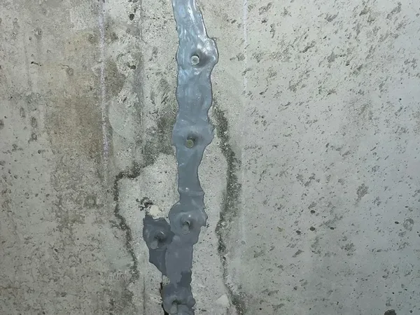 Foundation wall crack sealed with injection ports showing completed repair