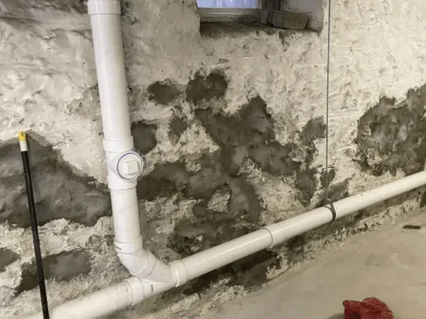 Stone foundation wall with mortar work and drainage pipes