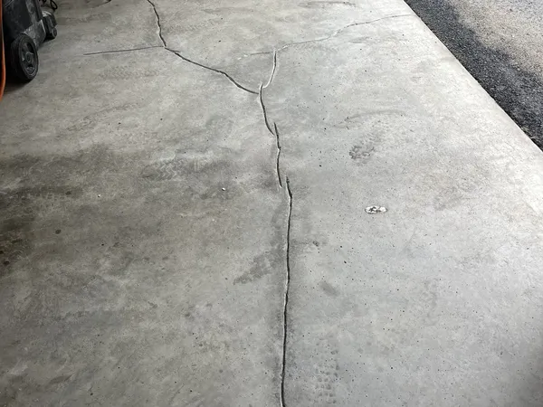 Open crack running through a garage concrete floor before repair
