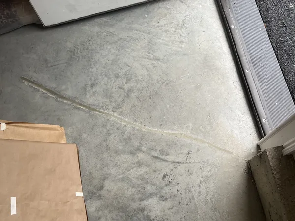 Finished concrete repair at the garage floor and wall joint