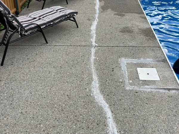 Cracked concrete pool deck in Franklin before repair