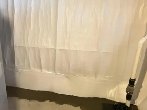Vapor barrier installation along basement walls for waterproofing