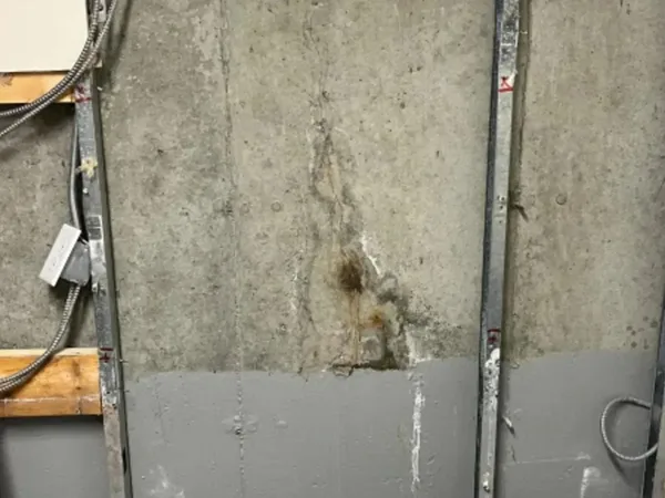 Poured concrete wall crack with water staining requiring repair